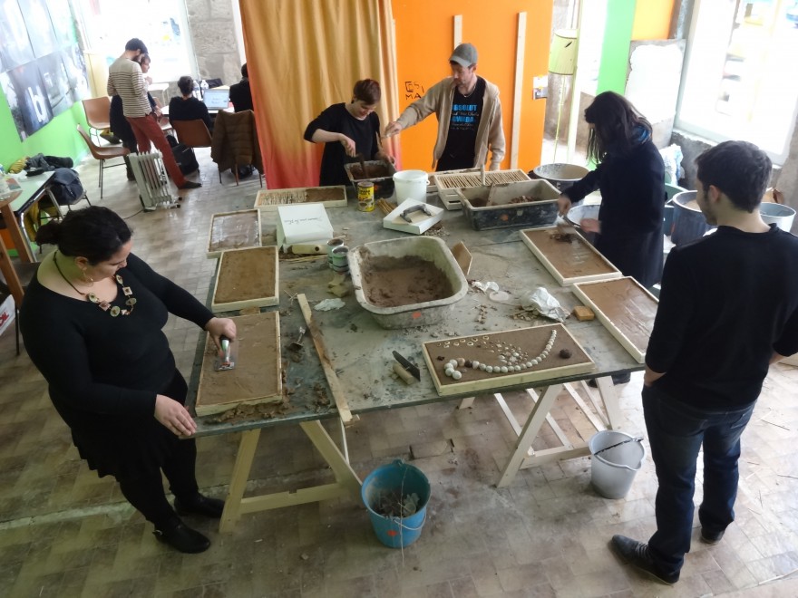 Une grande table de travail et des participants plongés dans la matière